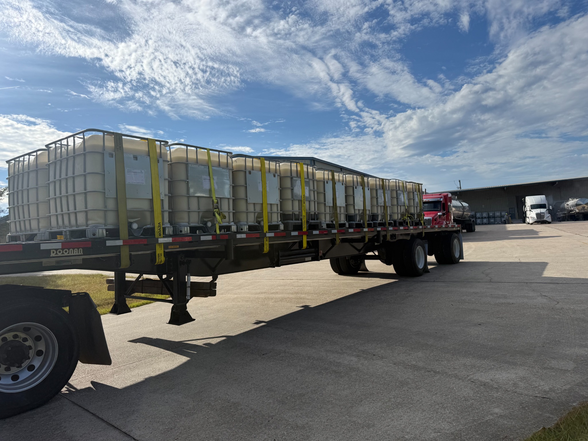 Flatbed carrying a full load of secured totes